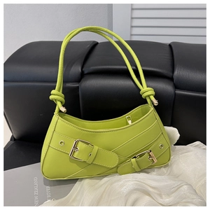 Detail of neon green leather shoulder bag with gold buckles and knotted handle design