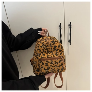 Close-up of leopard print corduroy mini backpack with front zipper and top handle