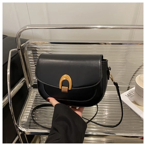 Détail du sac besace noir avec boucle dorée en U et texture en cuir synthétique mat
