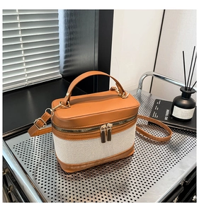 Vue détaillée du sac boîte rétro avec cuir marron et coutures en toile blanc cassé