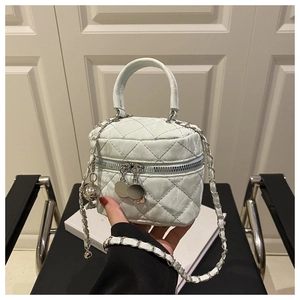Détail du sac matelassé vert menthe avec boule argentée et double fermeture éclair