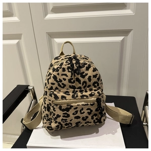 Close-up of leopard print corduroy texture and zipper front pocket on a mini backpack