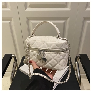 Détail du mini sac seau blanc matelassé avec chaîne dorée et double fermeture éclair