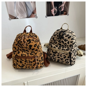 Close-up of leopard print mini backpacks in textured corduroy with zipper details
