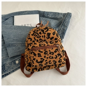 Detailed view of leopard print corduroy mini backpack with metal zippers and brown straps