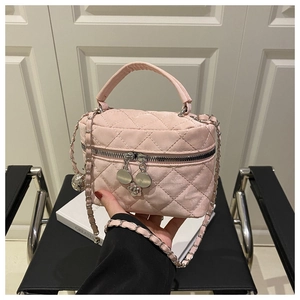 Détail du sac seau rose matelassé avec bandoulière chaîne et charms de fermeture éclair