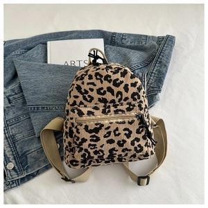 Detail of vintage leopard print corduroy backpack texture and black zipper on denim