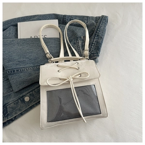 Detail of white transparent ita bag showing mesh window and decorative lace-up bow