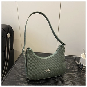 Detail of dark green woven hobo bag with a silver metallic bow decoration and zipper