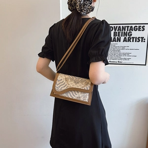 Vintage style cream crossbody bag with traditional wave embroidery and leather trim