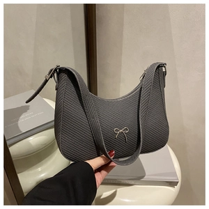 Close-up of dark grey woven texture shoulder bag featuring a silver metal bow detail