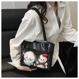 Detail of black PU leather tote with transparent PVC window and plush charms