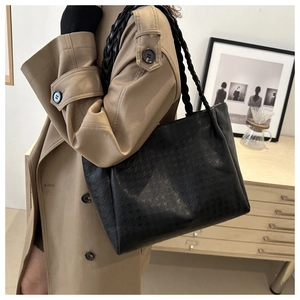 Détail du sac cabas noir avec texture pied-de-poule et bandoulière tressée