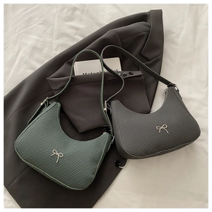 Detail of crescent moon bags with bow decor, woven texture, and adjustable strap