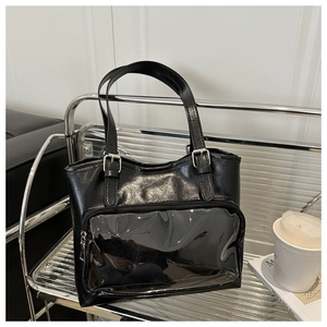Detail of black glossy Ita bag featuring clear PVC front window and silver buckles