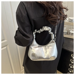 Close-up of silver hobo bag featuring a unique pleated handle and metallic chain strap