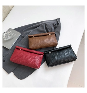 Detailed flat lay of woven envelope clutch bags in red, brown, and black colors
