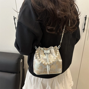 Elegant Chinoiserie bucket bag with pearl handle and traditional embroidery motifs