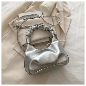 Detail of silver cloud handbag featuring pleated handles and elegant pearl pendant accent