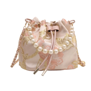 Pink satin bucket bag with floral embroidery and pearl handle shown on white background