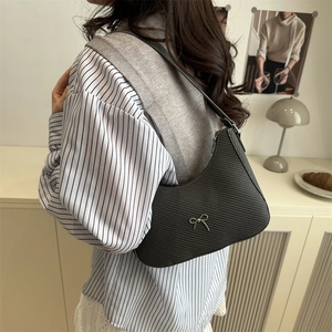 Chic black textured shoulder bag for women with a vintage silver bow decoration