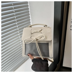 Dettaglio borsa quadrata crema con fiocco decorativo e inserto in rete mesh