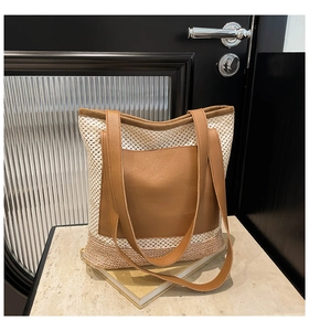 Detail of woven mesh tote bag with brown leather front pocket and matching shoulder straps