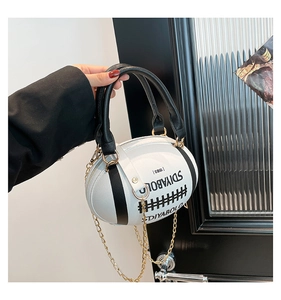 Macro detail of rugby-shaped leather handbag with gold chain strap and DIYABOLO text