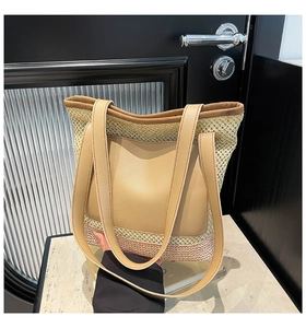 Detail of straw woven tote with leather patch pocket and shoulder straps