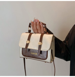 Detail of vintage square bag with cream and coffee contrast and textured pebble finish