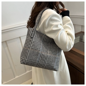 Classic black and white houndstooth tote bag on model for stylish daily commute