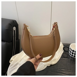 Detail of brown litchi pattern leather hobo bag with gold zipper and red lining