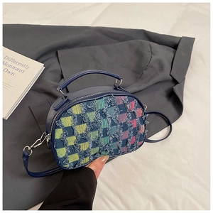 Detailed close-up of blue handbag with colorful checkered textured fabric and slim strap