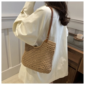 Detail of hand-woven crochet beach tote bag with premium brown leather shoulder straps