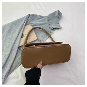 Détail d'un sac à main marron en cuir PU avec anse ronde et style vintage minimaliste