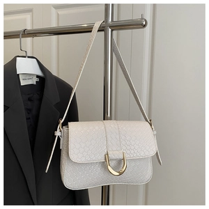 Detail of cream woven leather shoulder bag featuring a gold U-shaped metal buckle