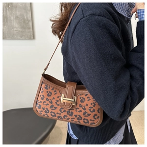 Détail du sac léopard avec garniture en cuir marron et boucle en métal doré