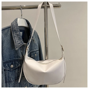 Detailed view of a white crescent moon shoulder bag featuring a sleek matte leather finish
