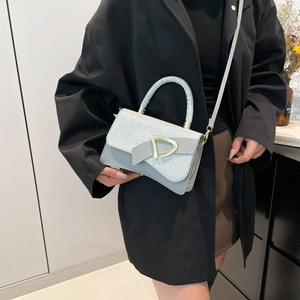 Chic light blue glitter crossbody bag with gold D-buckle and bow detail on top handle