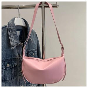 Pink faux leather crescent shoulder bag with adjustable strap and zipper closure details