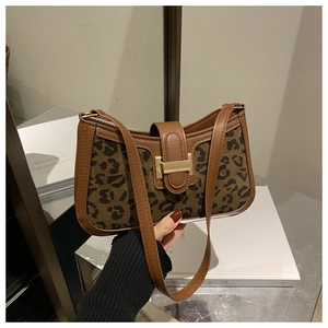 Détail d'un sac porté épaule léopard avec boucle en métal doré et liseré en cuir