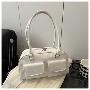 Detail shot of a minimalist white Boston tote bag with dual front flap pockets on fabric