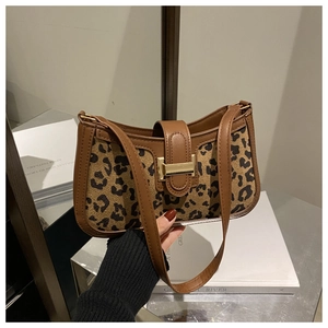Détail du sac sous le bras léopard vintage avec boucle dorée et bordure en cuir marron