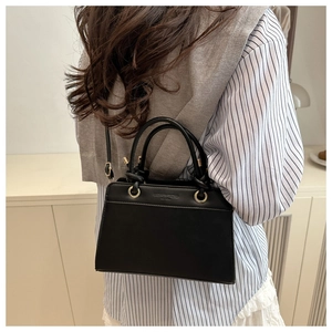 Detailed view of black minimalist handbag with Fashion Trend EST 1989 embossed text