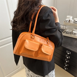 Chic vibrant orange glossy shoulder bag with dual front pockets for a modern daily look