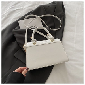 Detail of white leather tote with gold rings and Fashion Brand Est 1996 engraving