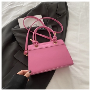 Detail of pink PU leather handbag featuring Fashion Trend embossing and gold hardware