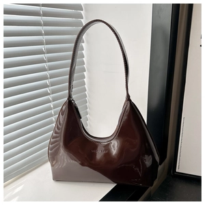 Detailed view of dark brown glossy patent leather hobo bag with GAILOAD CULT logo