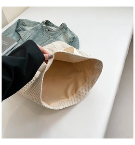 Détail de la doublure intérieure et de la texture tissée du sac fourre-tout en paille