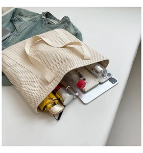 Grand sac fourre-tout tissé beige montrant le rangement pour téléphone, tablette et gourde